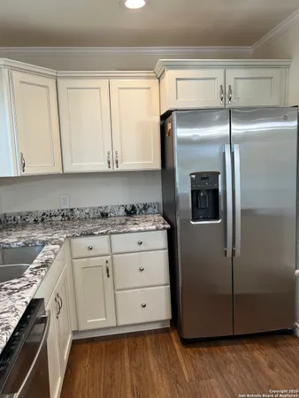a kitchen with a refrigerator sink and cabinets