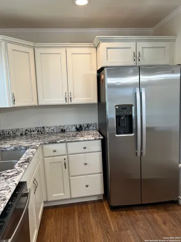 a kitchen with a refrigerator sink and cabinets