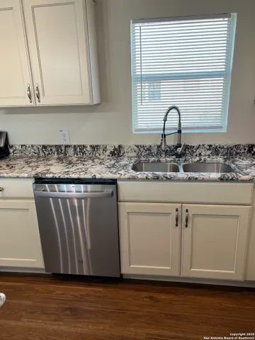 a kitchen with a sink cabinets and wooden floor