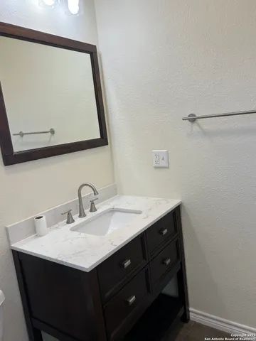 a bathroom with a sink vanity and a mirror