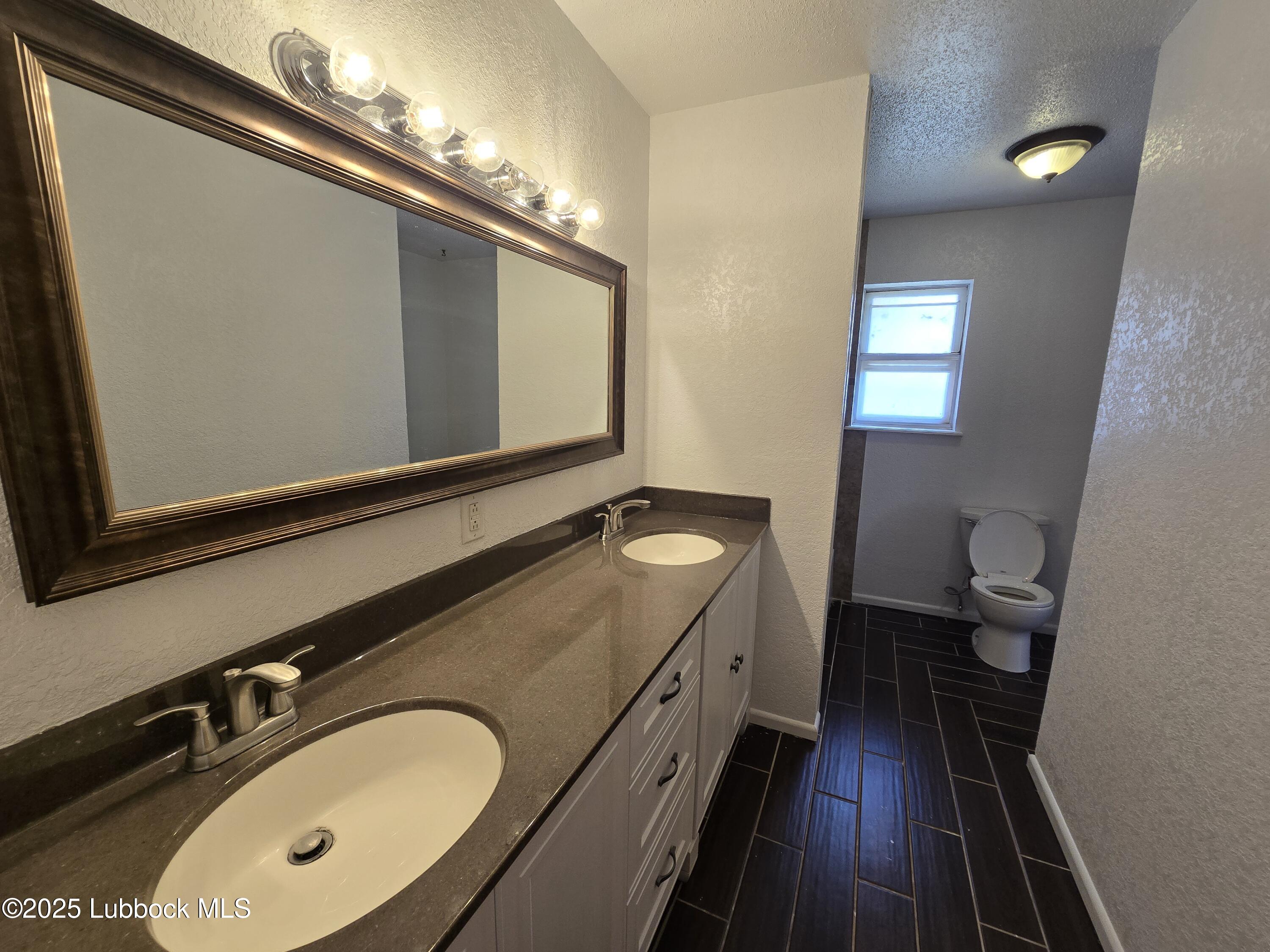 1681 Co Road Denver City, TX 79323 - Photo 14 of 30 a bathroom with a double vanity sink and a mirror