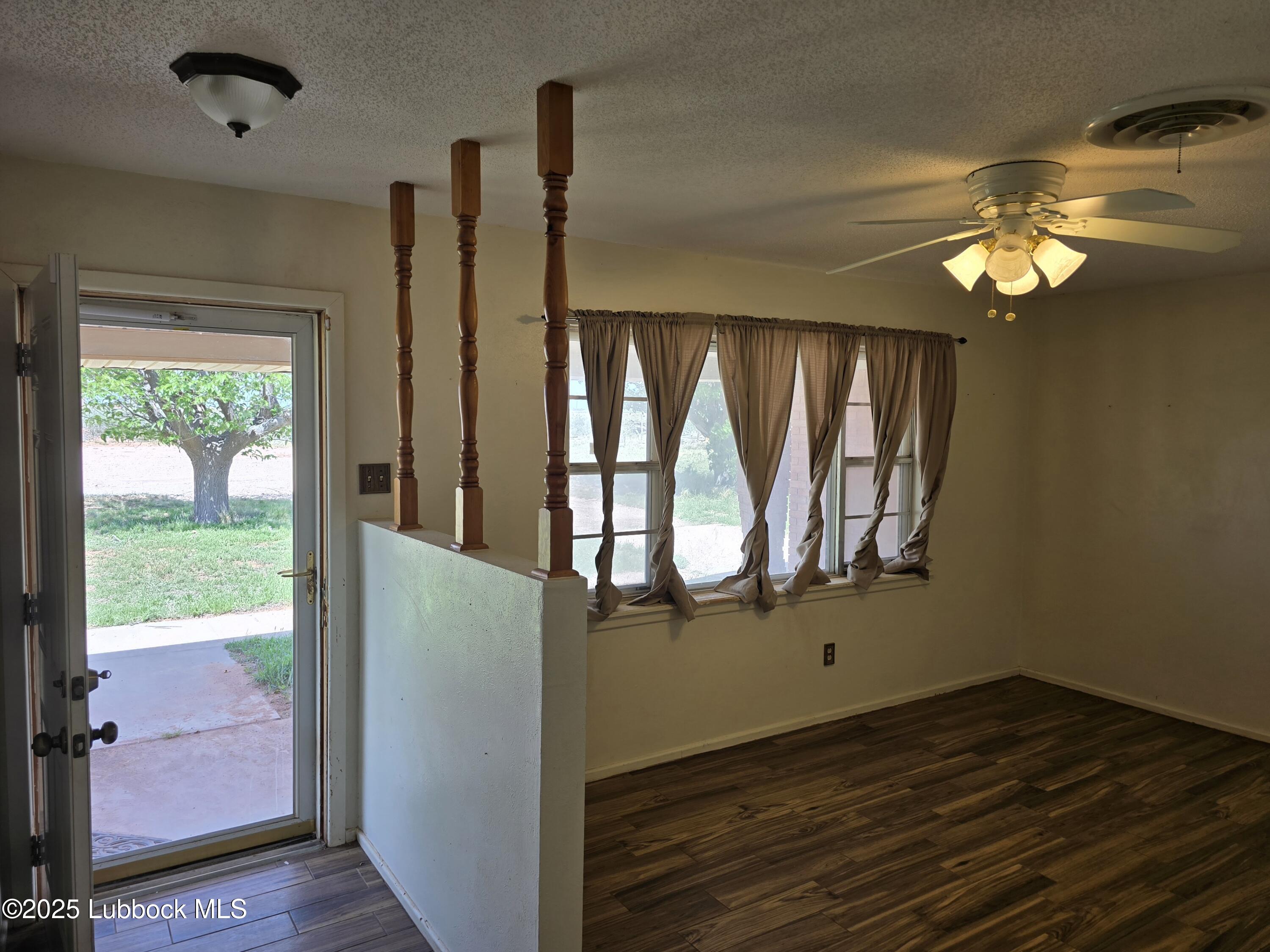1681 Co Road Denver City, TX 79323 - Photo 3 of 30 an empty room with wooden floor fan and windows