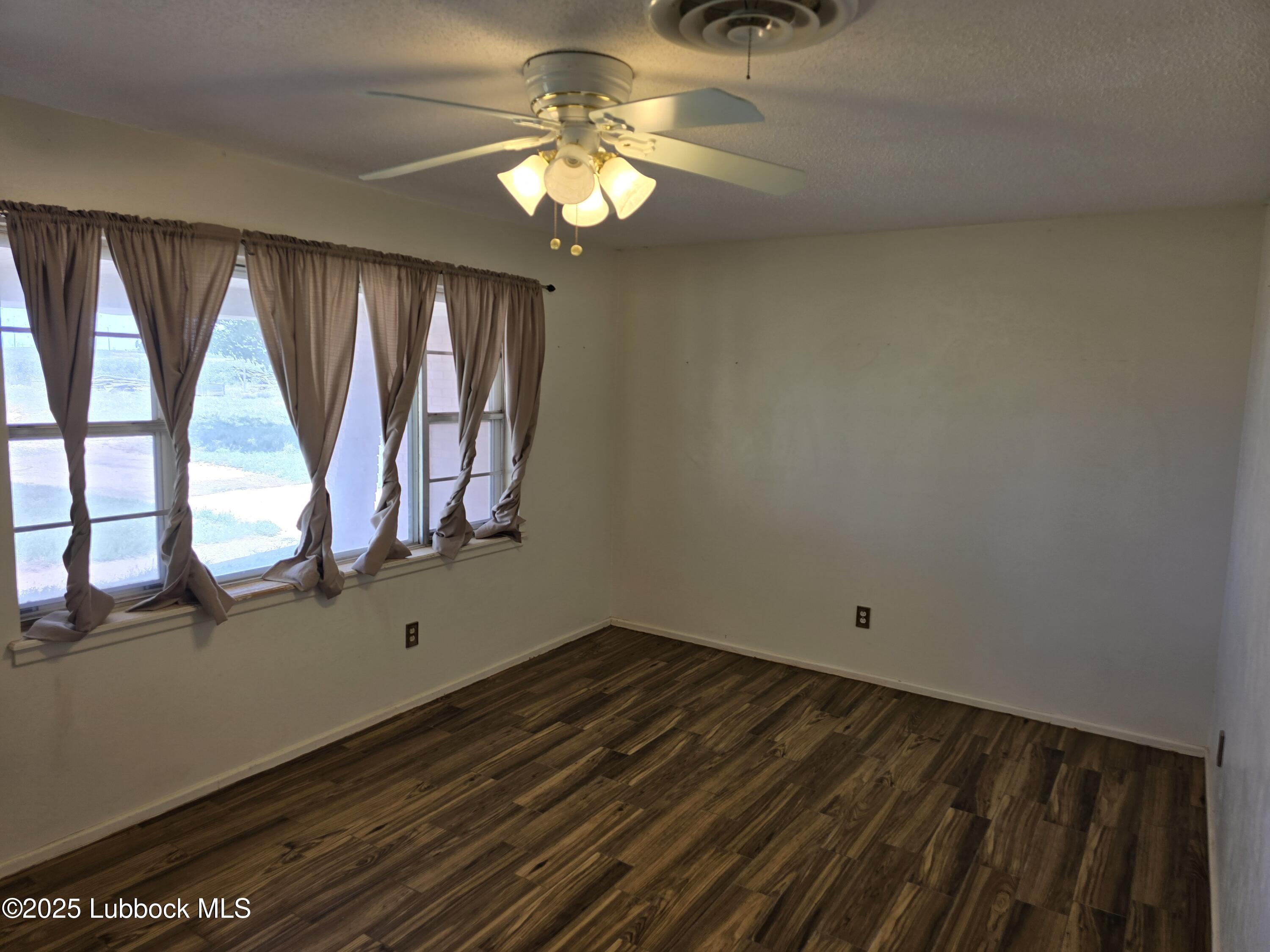 1681 Co Road Denver City, TX 79323 - Photo 5 of 30 wooden floor in an empty room with a window