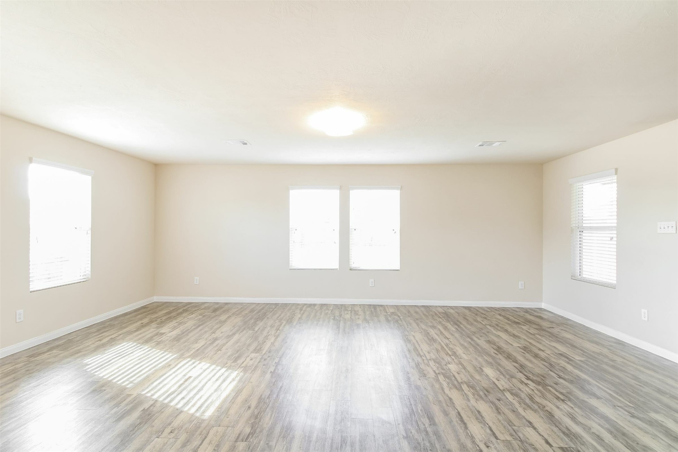 6002 Peaceful Ridge Drive Houston, TX 77048 - Photo 3 of 12 an empty room with wooden floor and windows
