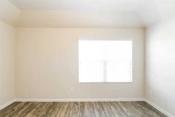 a view of a room with wooden floor and a window