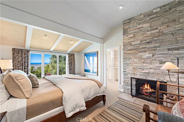a bedroom with a bed a fireplace and a large window