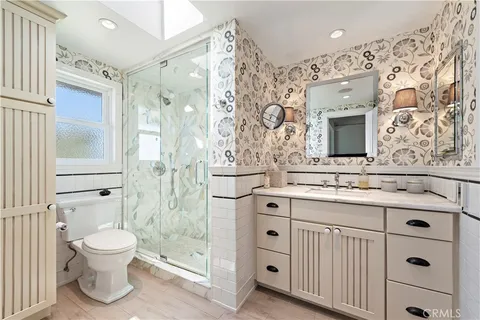 a bathroom with a sink a toilet and shower