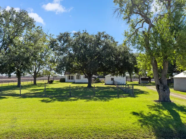 a front view of house with yard and trees in the background