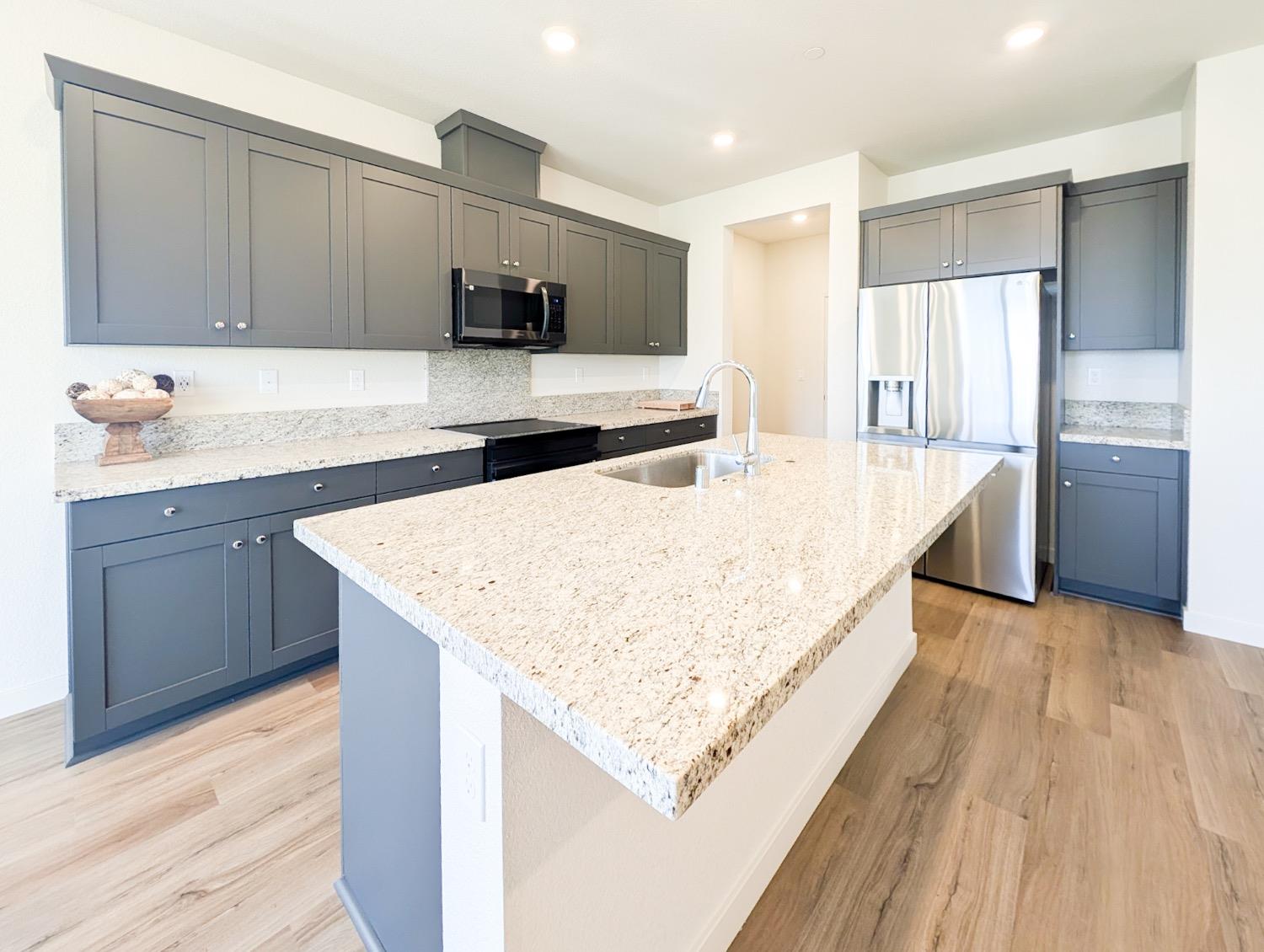 2129 Stagecoach Road Patterson, CA 95363 - Photo 13 of 23 a large kitchen with kitchen island a sink stainless steel appliances and cabinets