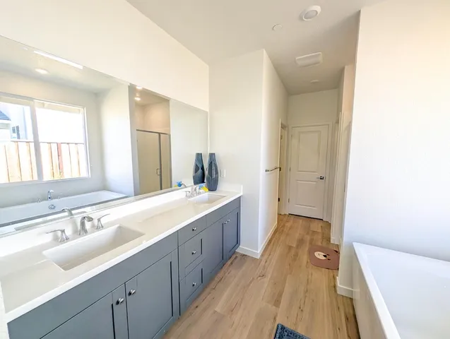 a spacious bathroom with a tub sink and mirror
