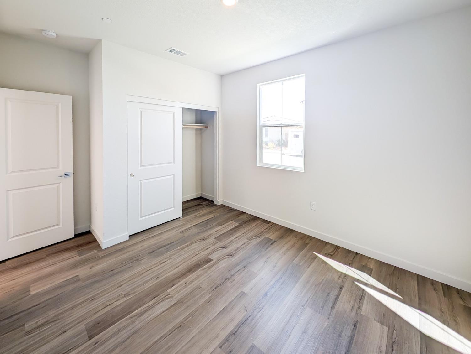 2129 Stagecoach Road Patterson, CA 95363 - Photo 4 of 23 an empty room with wooden floor and windows