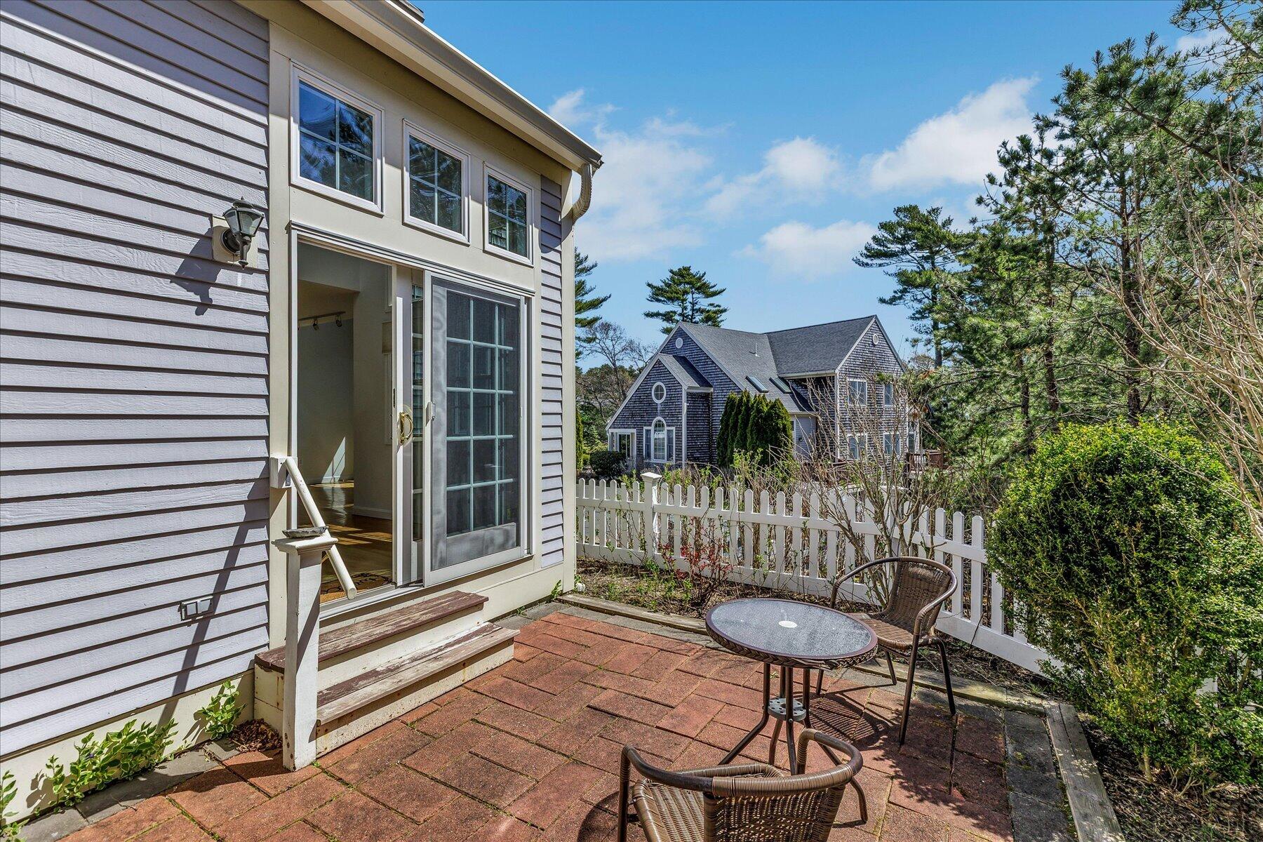 9 Red Cedar Road, Unit 9 Mashpee, MA 02649 - Photo 21 of 29 a view of a chair and tables in the balcony