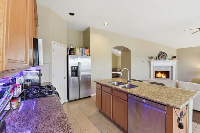 a kitchen with stainless steel appliances granite countertop a sink stove and refrigerator