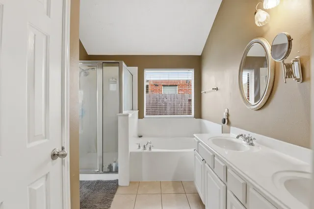 a bathroom with a tub sink and mirror
