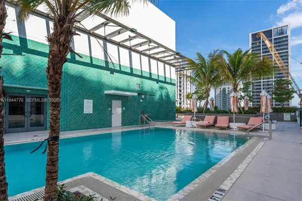 a view of a swimming pool with a bench and tables