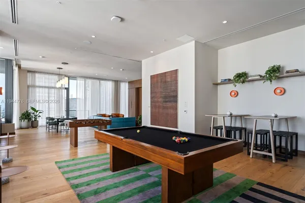a room with furniture pool table and a potted plant