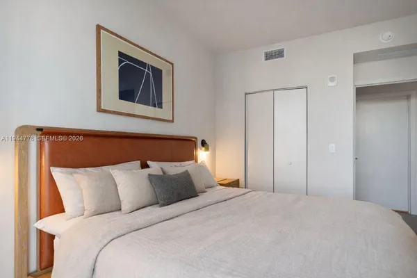a bedroom with bed and painting on the wall