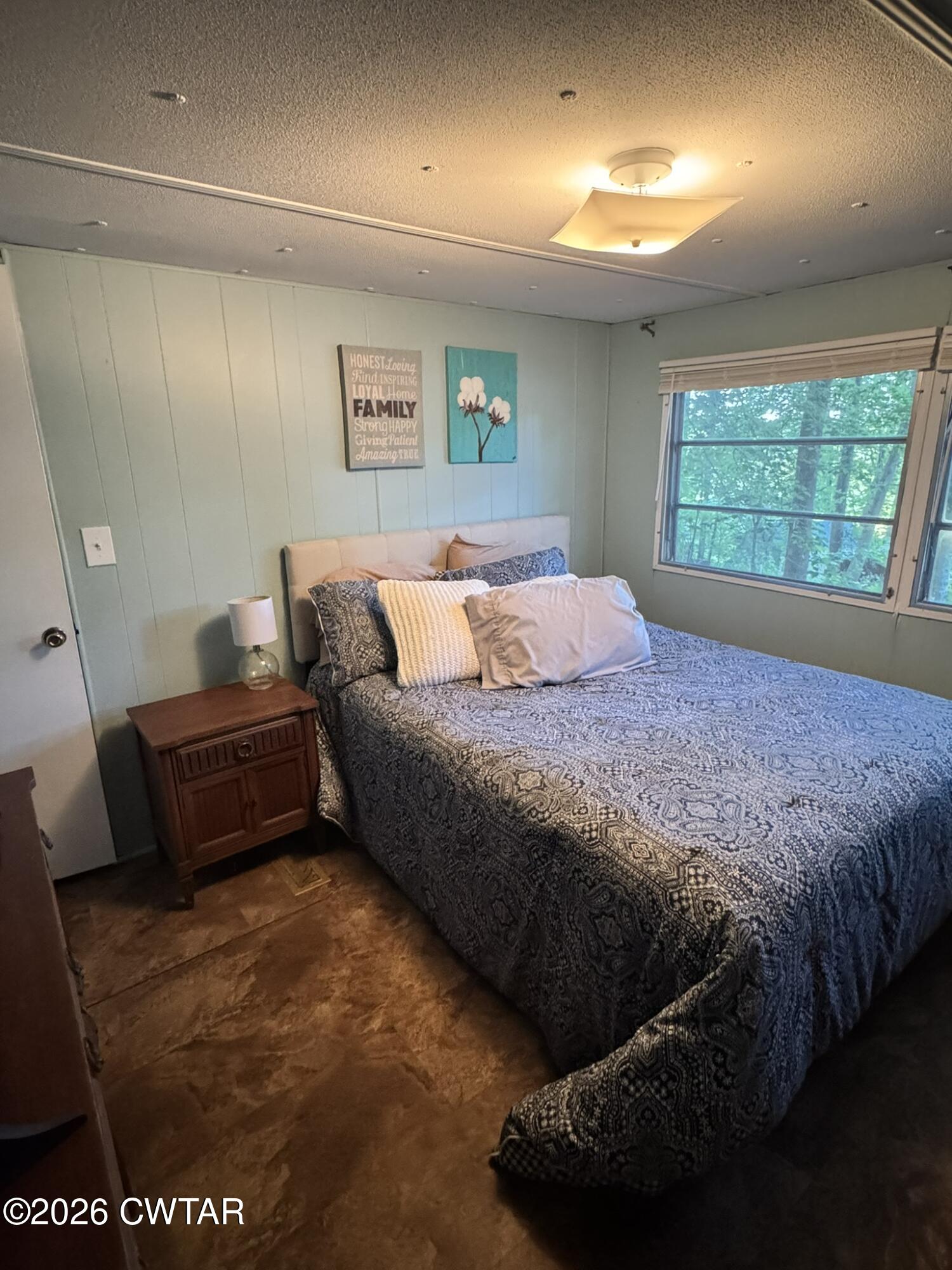 75 Elkins Road Decaturville, TN 38329 - Photo 3 of 8 a bedroom with a bed and a window