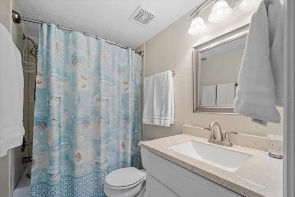 a bedroom with a large bed and a flat tv screen on dresser