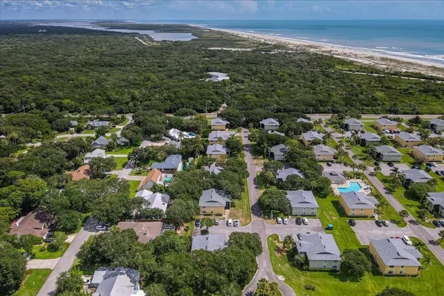 an aerial view of residential houses with outdoor space and trees