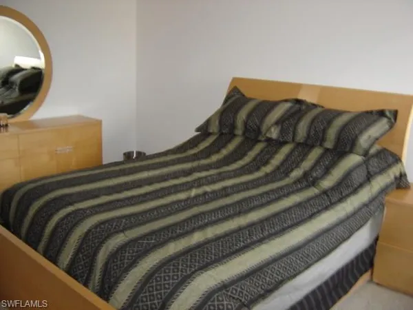 a bedroom with a bed and a mirror