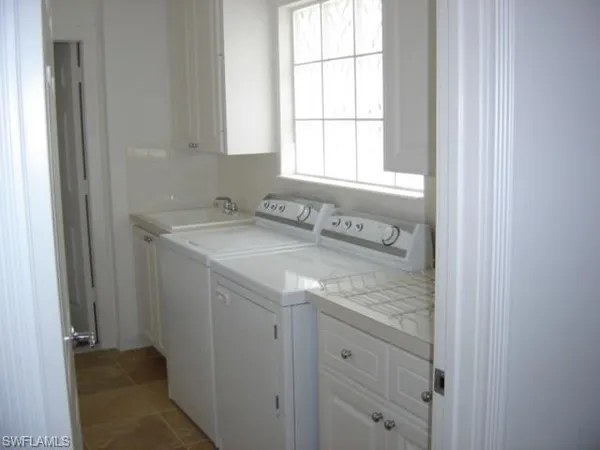 a bathroom with a granite countertop sink and a window