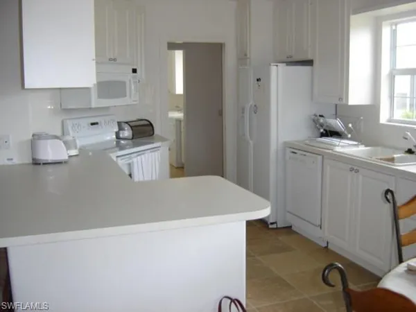a kitchen with a sink a stove and cabinets