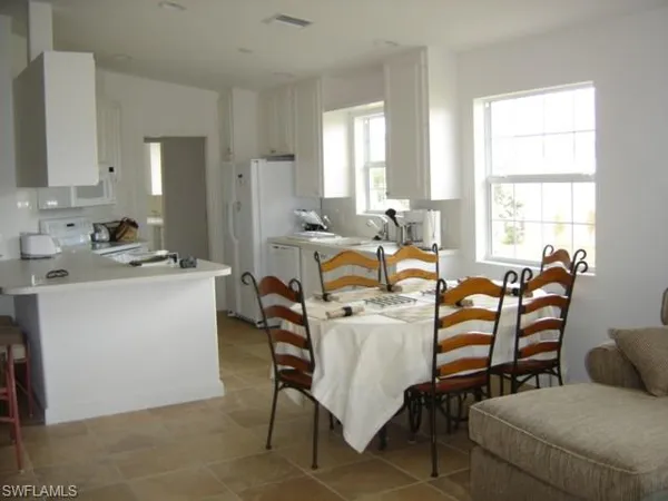 a living room with furniture a large window and white appliances