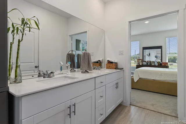 a en suite bathroom with a double vanity sink and a mirror