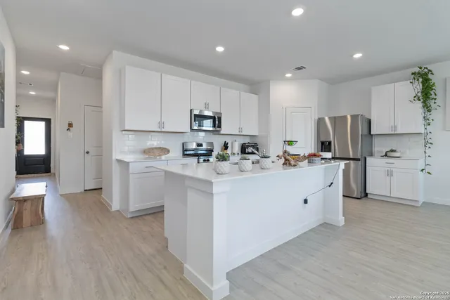 a kitchen with cabinets a sink and a refrigerator
