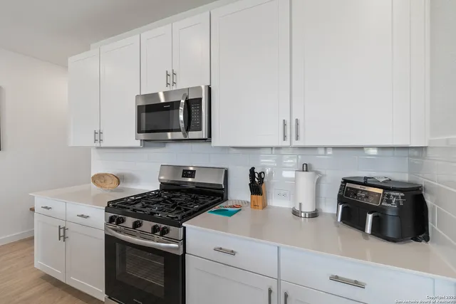 a kitchen with appliances a sink and cabinets