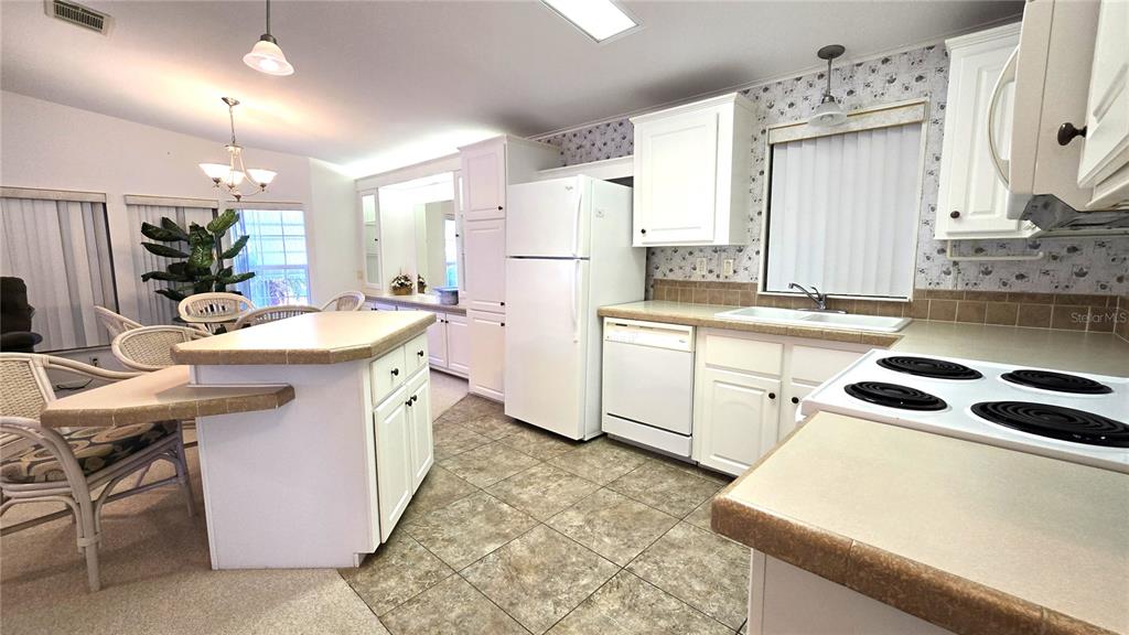 10303 Burnt Store Road, Unit 93 Punta Gorda, FL 33950 - Photo 14 of 65 a kitchen with a sink a stove a refrigerator and cabinets