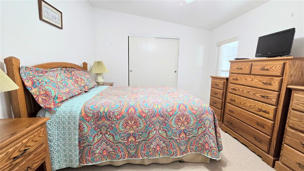 10303 Burnt Store Road, Unit 93 Punta Gorda, FL 33950 - Photo 19 of 65 a bedroom with a bed and tv on the dresser