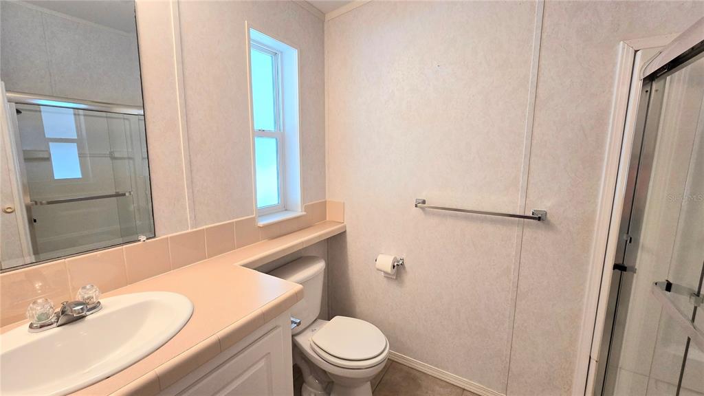 10303 Burnt Store Road, Unit 93 Punta Gorda, FL 33950 - Photo 21 of 65 a bathroom with a granite countertop sink toilet and shower