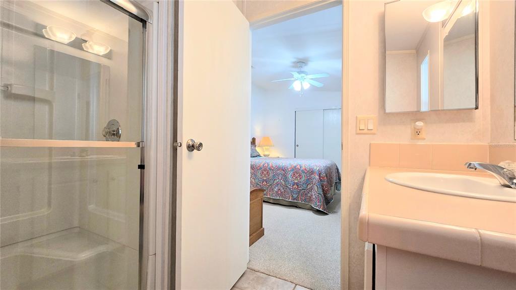 10303 Burnt Store Road, Unit 93 Punta Gorda, FL 33950 - Photo 23 of 65 a en suite bathroom with a tub sink and mirror