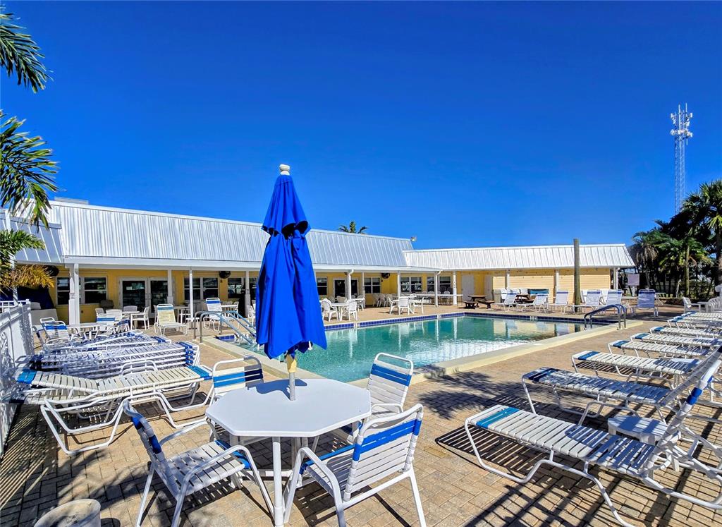10303 Burnt Store Road, Unit 93 Punta Gorda, FL 33950 - Photo 64 of 65 a view of a patio with swimming pool table and chairs