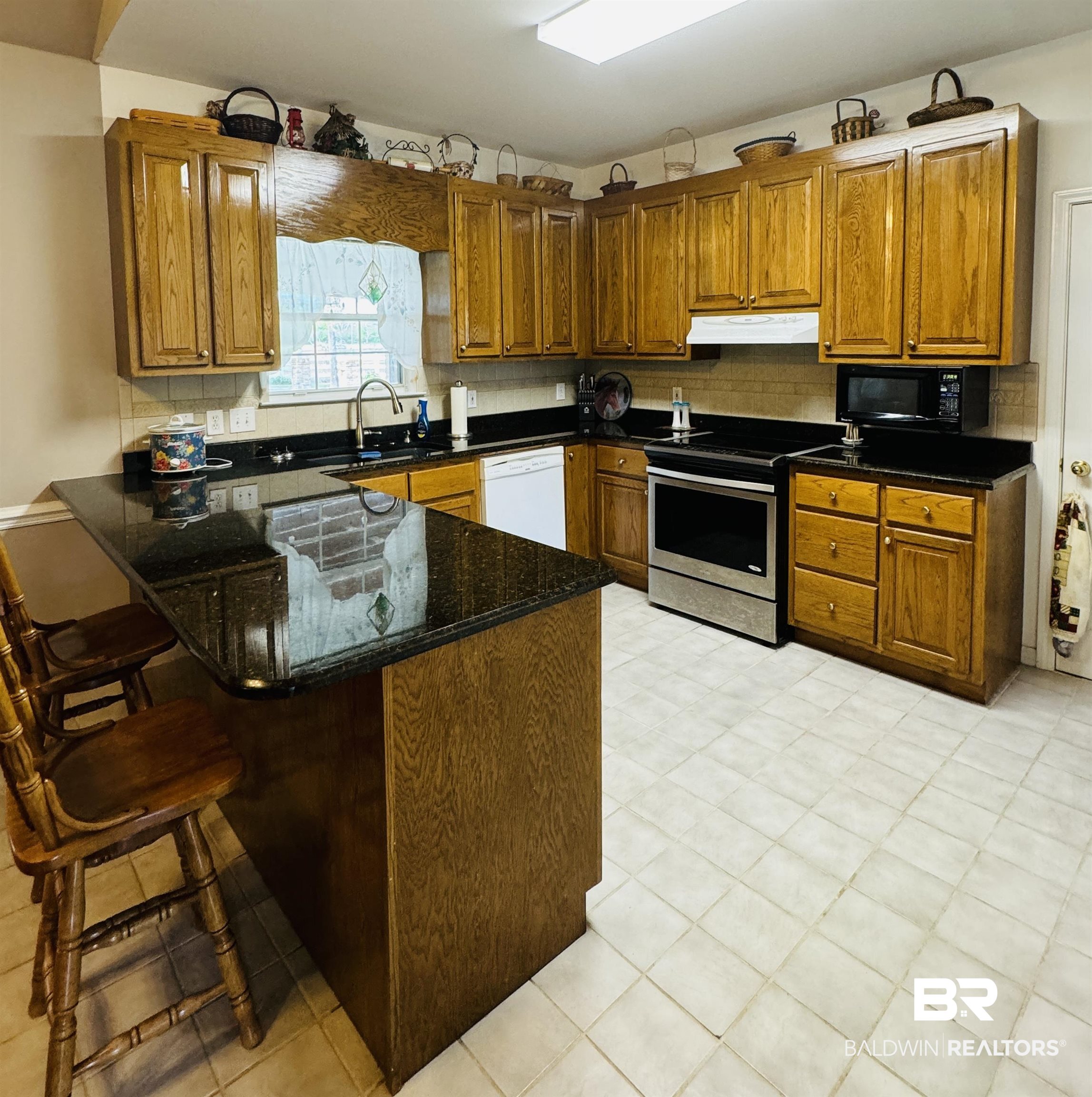 13795 White Road Silverhill, AL 36576 - Photo 28 of 99 Kitchen featuring wood finish cabinetry, a peninsula, electric range, and a breakfast bar