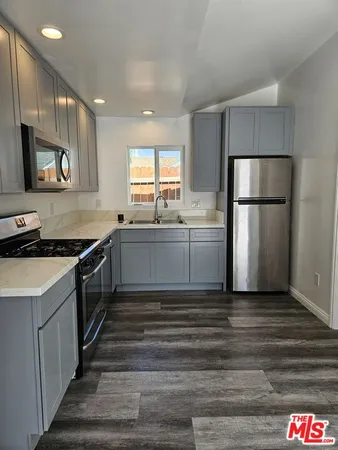 a kitchen with stainless steel appliances a refrigerator sink and stove