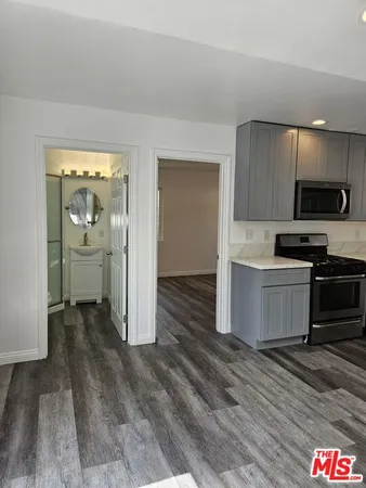 a kitchen with granite countertop a refrigerator and a stove top oven