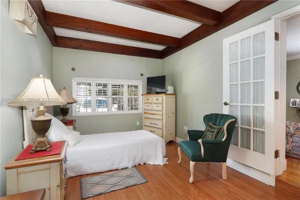 a bedroom with a bed and wooden floor