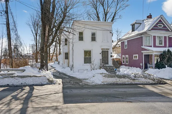 a front view of a house with a yard covered with snow