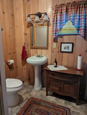 a bathroom with a toilet a sink and mirror