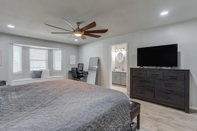a bedroom with a bed and a flat screen tv