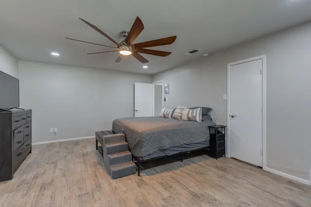 a bedroom with a bed and a ceiling fan
