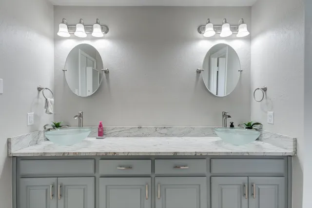 a bathroom with double vanity sinks and a mirror