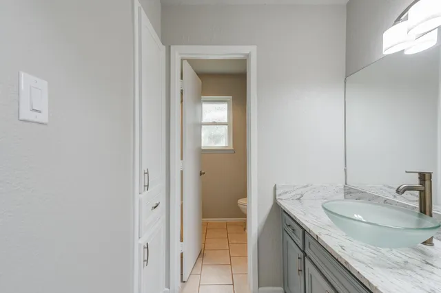 a bathroom with a granite countertop sink and a mirror