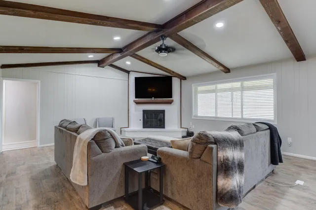 a living room with furniture a window and a flat screen tv