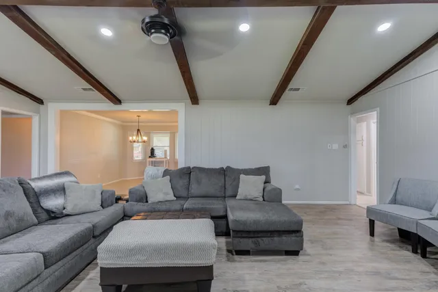 a living room with furniture and a ceiling fan