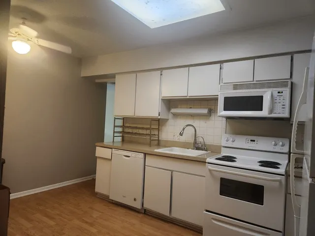 a kitchen with stainless steel appliances white cabinets and a sink