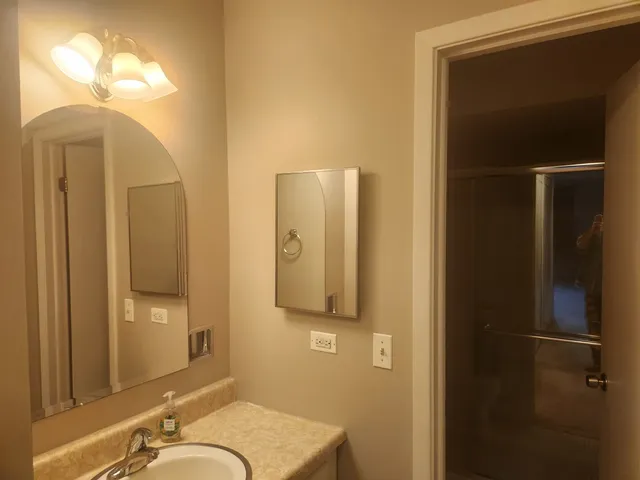 a bathroom with a granite countertop sink and mirror